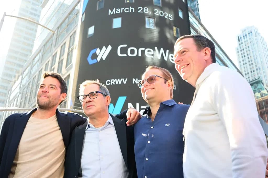 CoreWeave executives posing in front of the Nasdaq tower on their IPO day